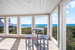 Enjoy ocean views from this outdoor space with a wooden deck and a circular table for two.