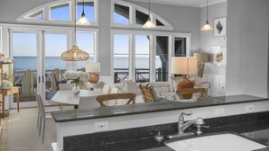A modern kitchen with a large island, a dining area with a view of the ocean, and a spacious living area with large windows. - Amazing Gulf Views 425a Watersound Crossings 3br Steps To Beach And Pool! 3 Bedroom Condo by RedAwning (Santa Rosa Beach)