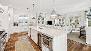 A modern kitchen with white cabinetry, a large island, stainless steel appliances, and pendant lighting. - 'mirasol House' Pool + Golf Cart Watercolor, Fl 4br/4ba/bonus Bunk -- Sleeps 12 4 Bedroom Home by RedAwning (Santa Rosa Beach)