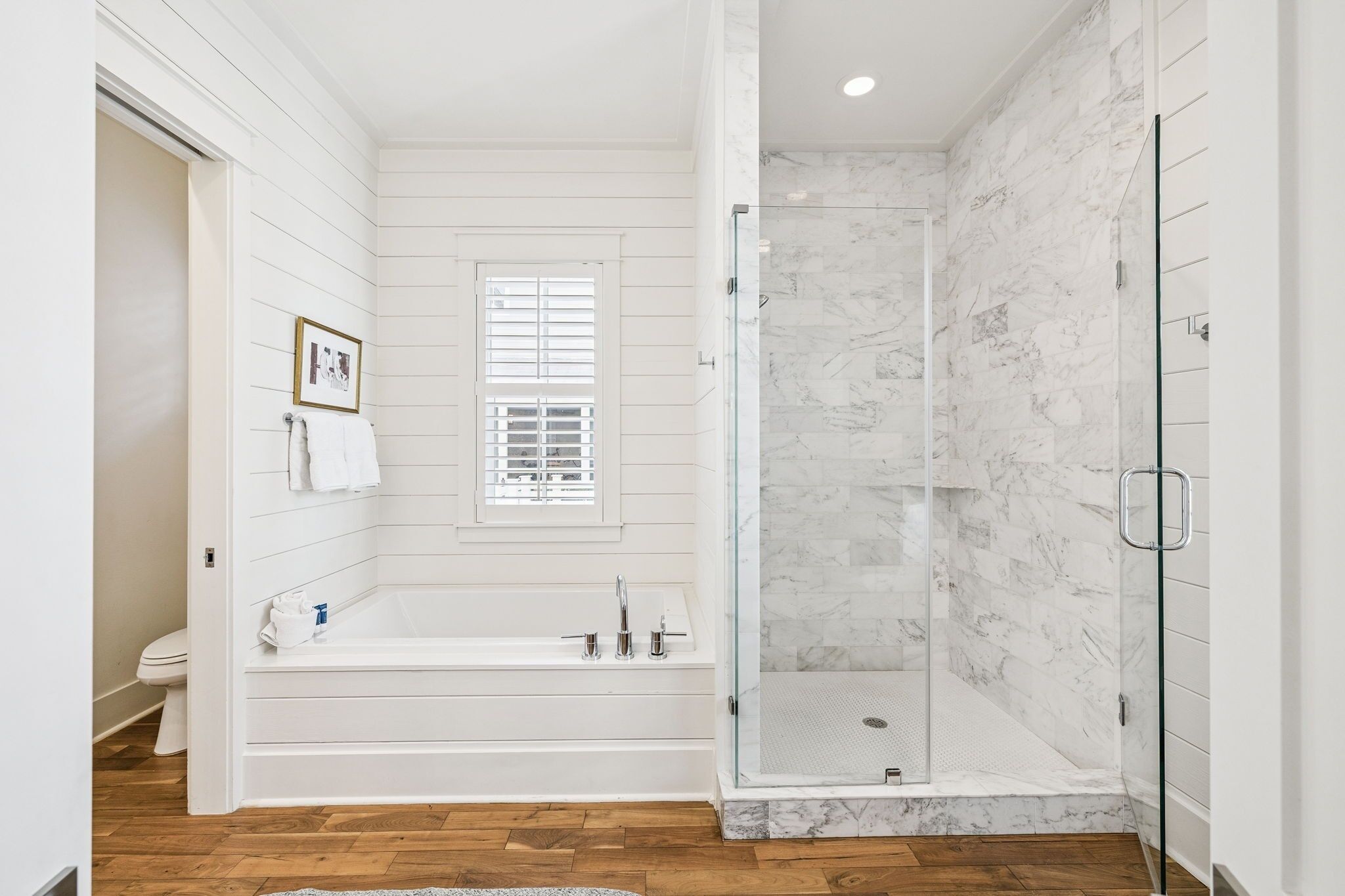 Une salle de bain moderne avec une douche à l’italienne, une baignoire et des toilettes.