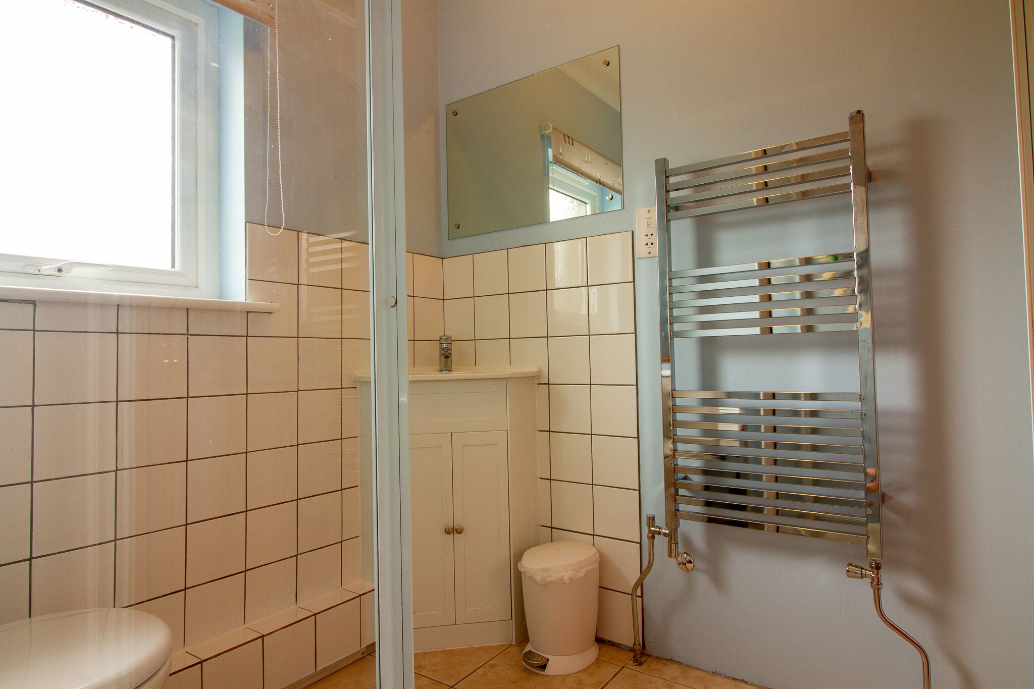 Ein Badezimmer mit Toilette, Dusche, Spiegel und Handtuchhalter.
