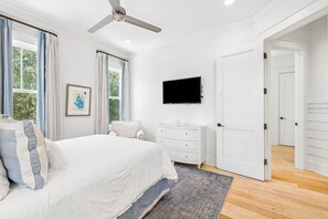 A bedroom with a bed, a dresser, a television, and a door leading to another room. - Private Pool And Close To Sandhill Pool - Watercolor Lake District Home 4 Bedroom Home by RedAwning (Santa Rosa Beach)