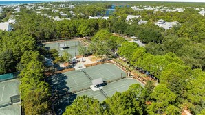 An aerial view of a residential area with multiple tennis courts surrounded by dense trees. - Private Pool And Close To Sandhill Pool - Watercolor Lake District Home 4 Bedroom Home by RedAwning (Santa Rosa Beach)