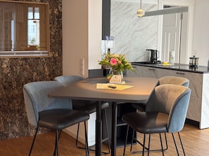 A modern kitchen with a marble countertop, a built-in oven, and a hanging light fixture. - "Meeresbrise" Luxury Apartment with Sauna & Ocean View | Terrace | Near the Beach | Dog-Friendly (Binz)