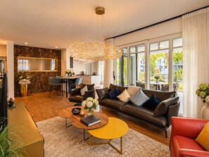 Un salon moderne avec un canapé, une table basse et un coin repas avec des chaises.