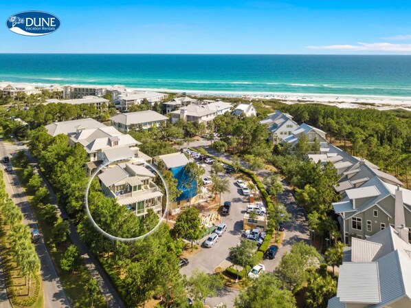 An aerial view of a resort with multiple buildings, a parking area, and a beach in the background. - Steps To Beach Club, Multi-level Watercolor Condo, Slps 4, Perfect Location! 1 Bedroom Condo by RedAwning (Santa Rosa Beach)