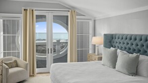 A hotel room with a large bed, a chair, a nightstand, and a view of the ocean through a glass door. - amazing Gulf Views 420b Watersound Crossings 3br, Corner Unit 3 Bedroom Condo by RedAwning (Santa Rosa Beach)