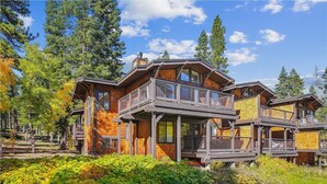 A multi-story wooden cabin with a balcony, surrounded by a forest. - Serene Forest-Front Retreat: 4BR Rocky Ridge Gem (Tahoe City)