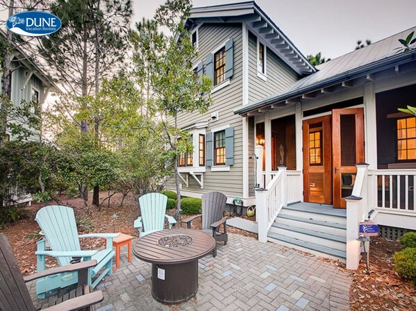 A two-story house with a porch, outdoor seating, and a fire pit. - 'serendipity' Beautiful 3br Cottage Sleeps 8 close To Lazy River/pool At Camp Watercolor 3 Bedroom Home by RedAwning (Santa Rosa Beach)