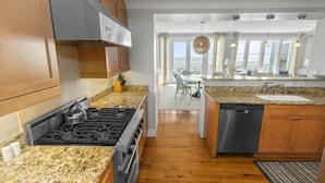 A modern kitchen with granite countertops, stainless steel appliances, and wooden cabinets. - Beautiful Gulf Views Spacious, Updated 316b Watersound Crossings Steps To Beach And Pool 3 Bedroom Condo by RedAwning (Santa Rosa Beach)