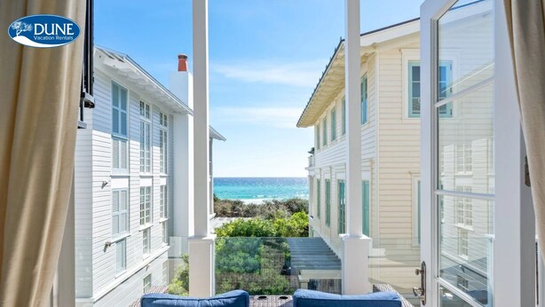 A balcony with wicker furniture and a view of the ocean. - Gulf Views Steps To Seaside Town Center Bella Vita - Newly Remodeled! 4 Bedroom Home by RedAwning (Santa Rosa Beach)