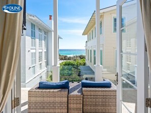 A balcony with wicker furniture and a view of the ocean. - Gulf Views Steps To Seaside Town Center Bella Vita - Newly Remodeled! 4 Bedroom Home by RedAwning (Santa Rosa Beach)