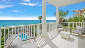 A covered balcony with a pool, white furniture, and a view of the ocean. - Shellstone Cottage Beach Front Seacrest Home with Private Pool and 5 Bedrooms 4 Home by RedAwning (Panama City Beach)