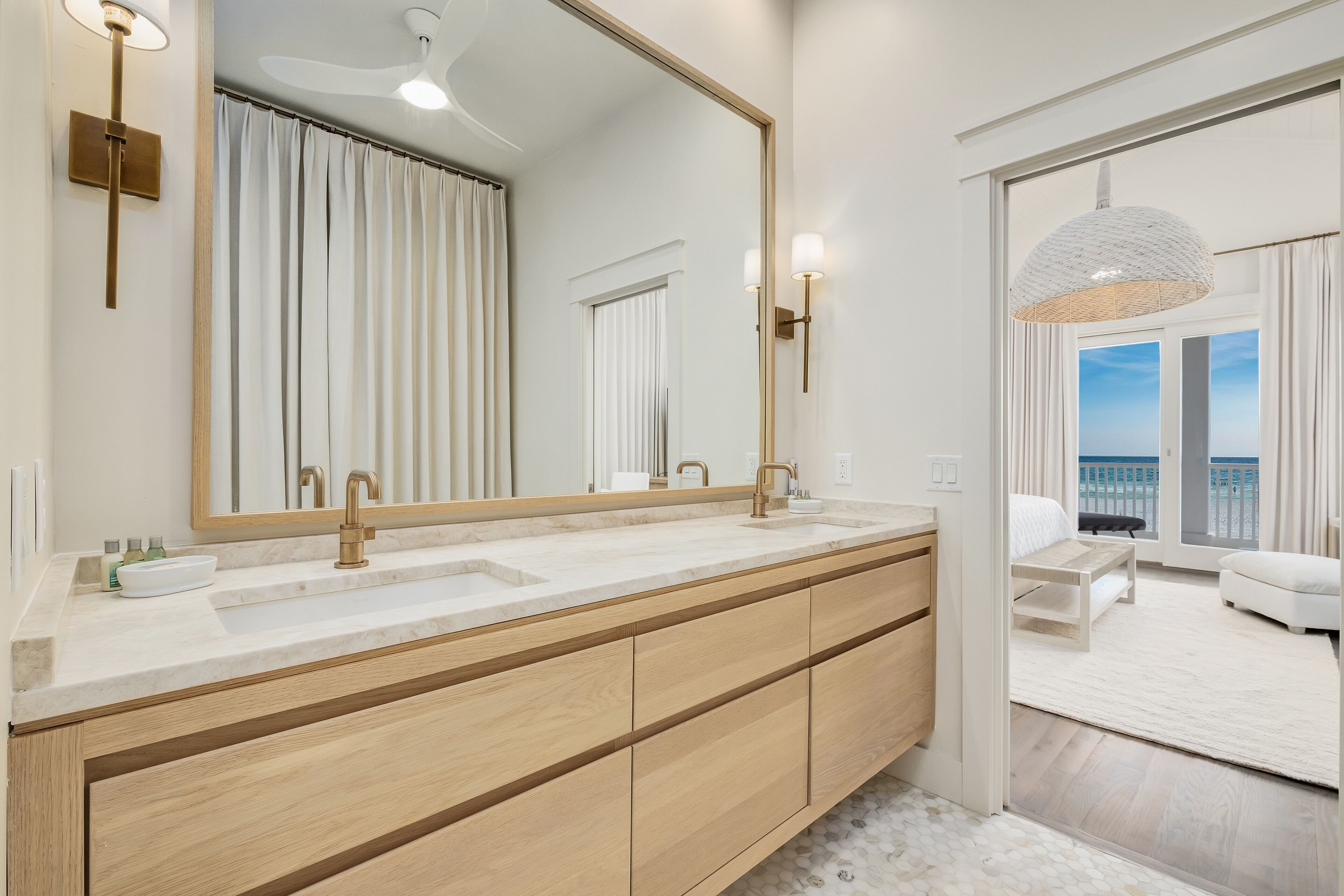 A modern bathroom with a large mirror, dual sinks, and a wooden vanity.