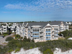 A large, multi-story beachfront hotel with balconies, a parking lot, and surrounding greenery. - Gulf Front Penthouse Condo Complimentary Golf Cart 407 Compass Point 1, Watersound - 3 Br, Slps 8 3 Bedroom Condo by RedAwning (Santa Rosa Beach)