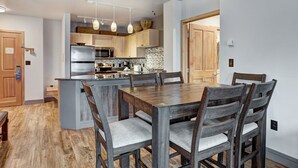 Una cocina moderna con armarios de madera, una isla central e iluminación colgante.