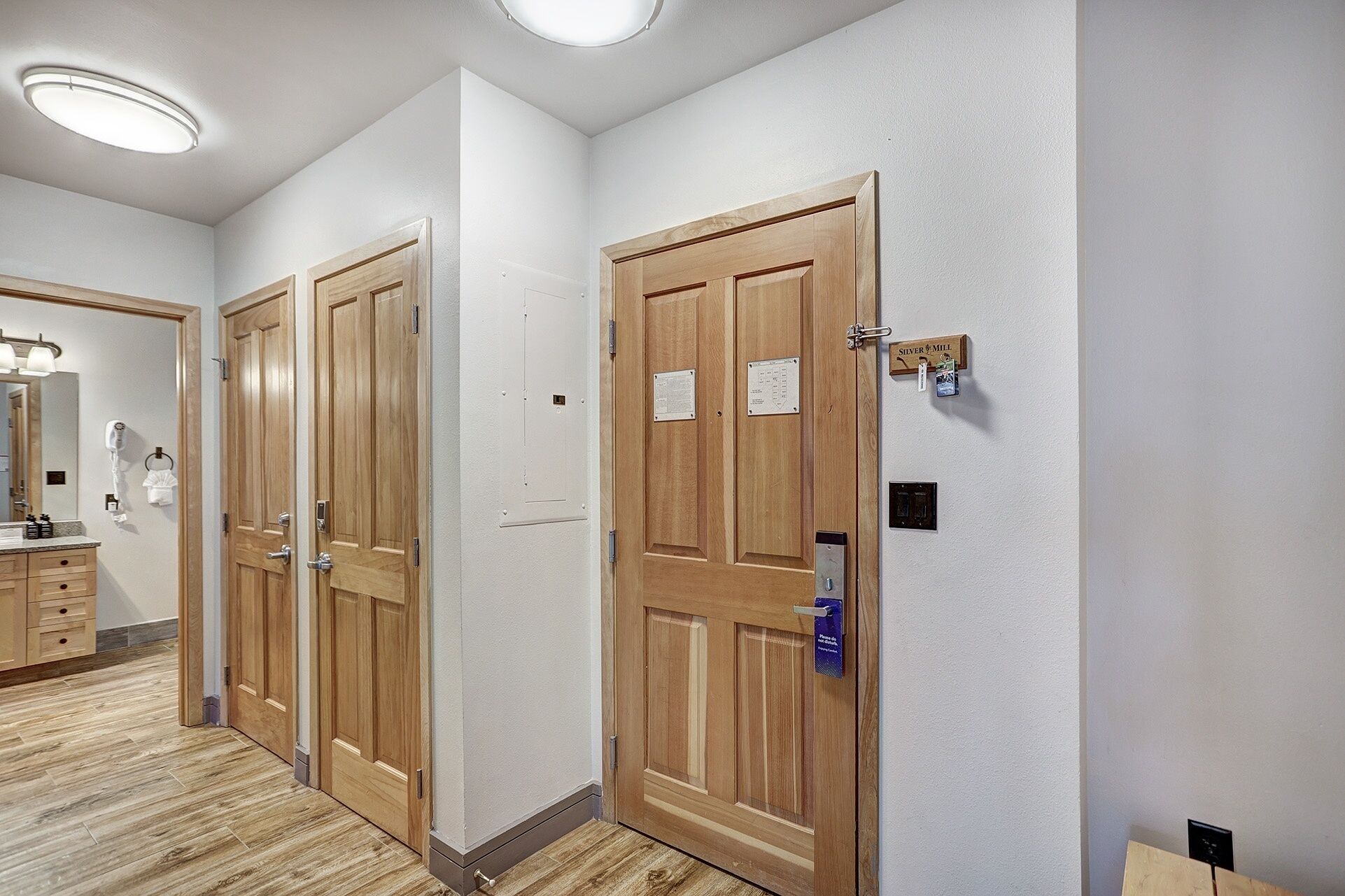 Ein Hotelkorridor mit Holztüren, einem Spiegel und einem Schminktisch mit Toilettenartikeln.