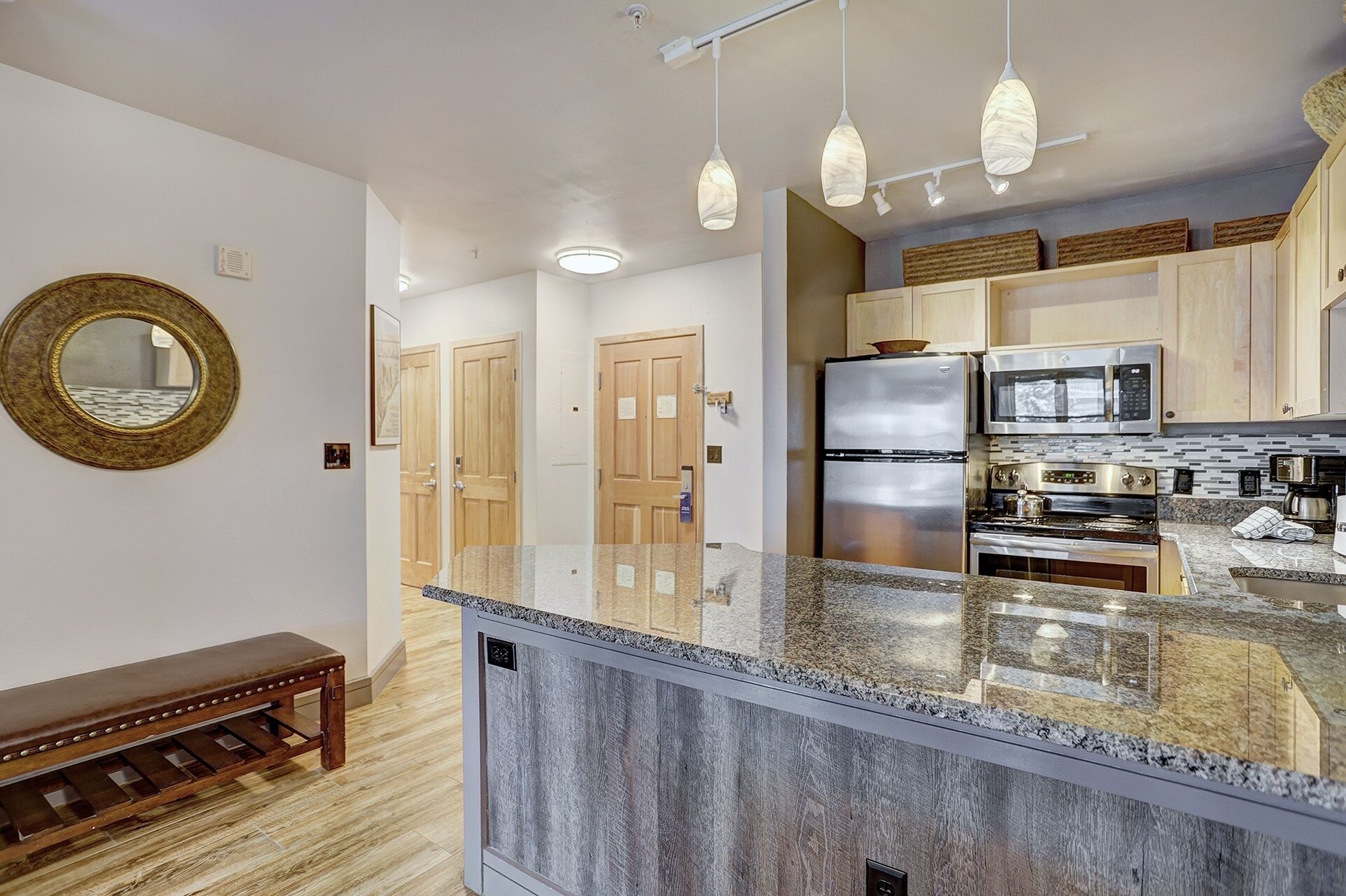A modern kitchen with granite countertops, stainless steel appliances, and wooden cabinets.