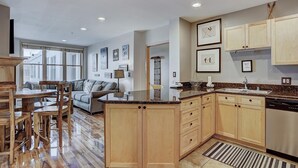 A modern kitchen with wooden cabinets, a granite countertop, and a built-in dishwasher.