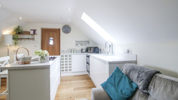 Eine moderne Loftswohnung mit Küche, Essbereich und Wohnzimmer.
