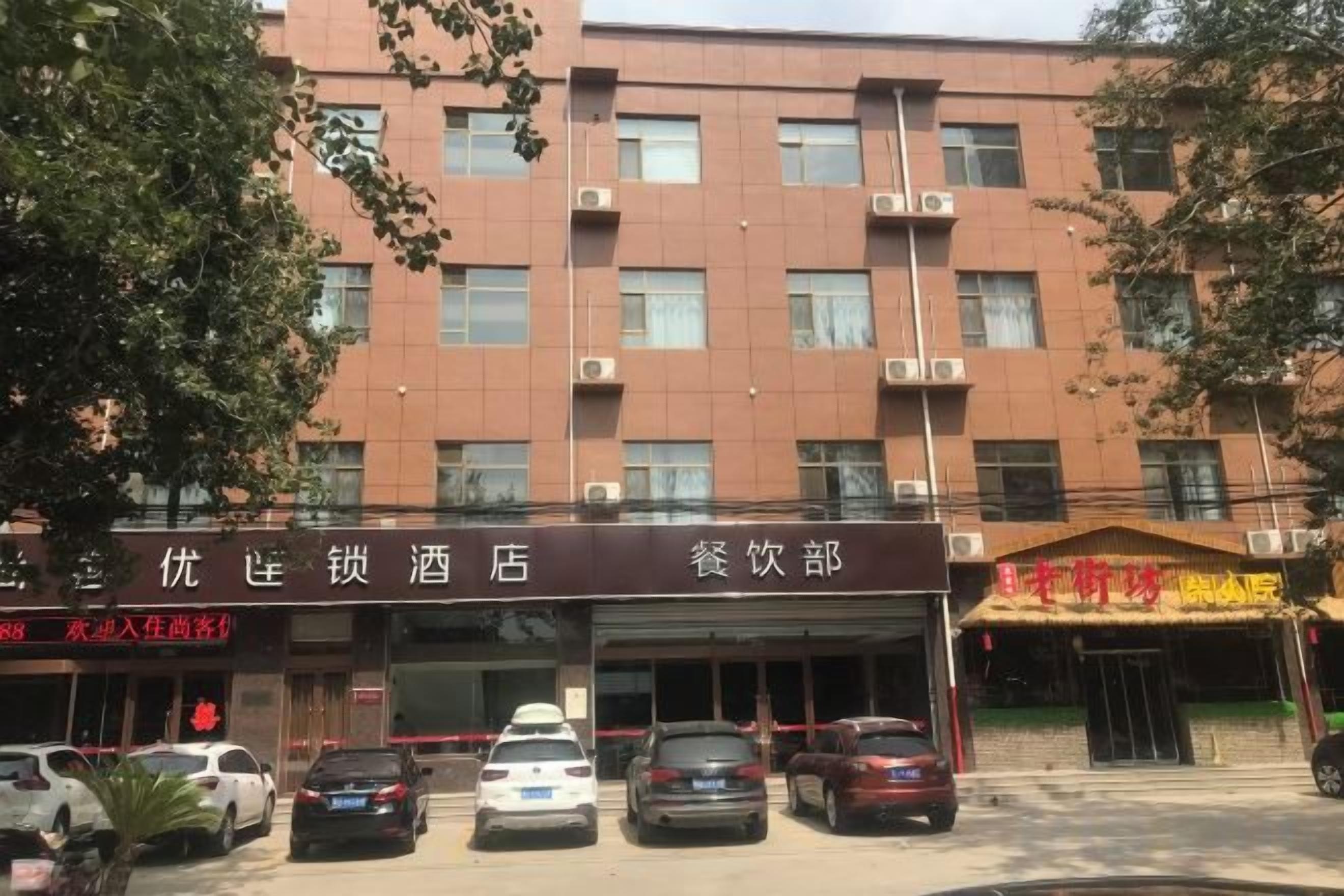 Un edificio de varios pisos con restaurante y estacionamiento.
