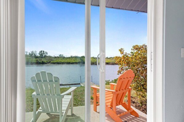 Relax in a serene outdoor space with two Adirondack chairs overlooking a peaceful body of water.