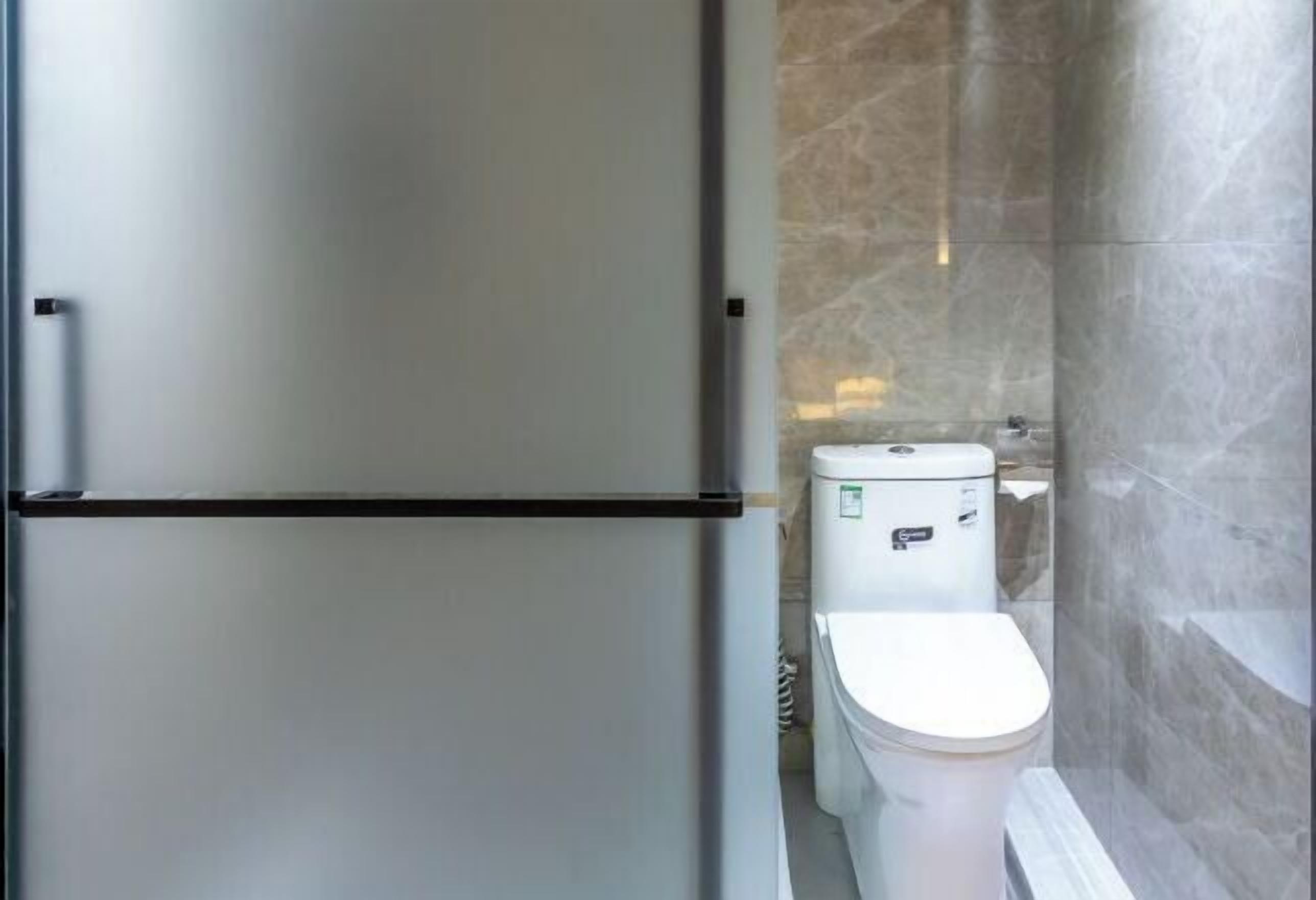 A bathroom with a toilet, a sink, and a mirror.