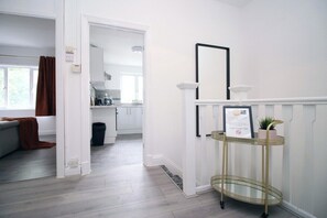Enter a clean and bright space with a kitchen area featuring modern appliances and a countertop.