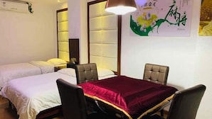 A hotel room with two beds, a dining table with chairs, a pendant light, and a wall with artwork. - Fu an Hotel (Guangzhou)