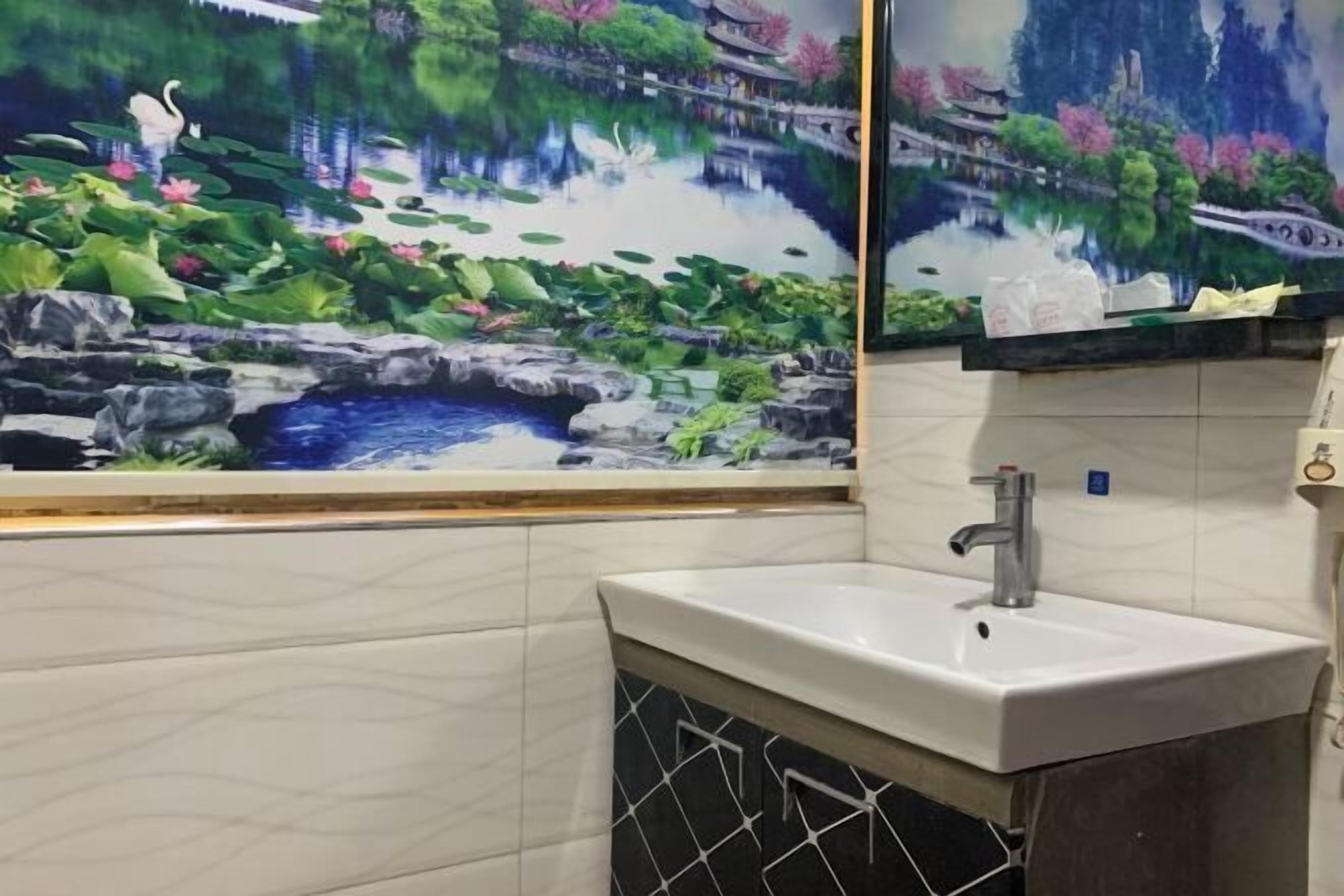 Um banheiro com pia, espelho e um mural decorativo retratando uma paisagem tranquila com água, flores de lótus e arquitetura tradicional.