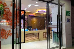 A reception area with a glass door, a reception desk, and a wall with a floral design. - Fu an Hotel (Guangzhou)