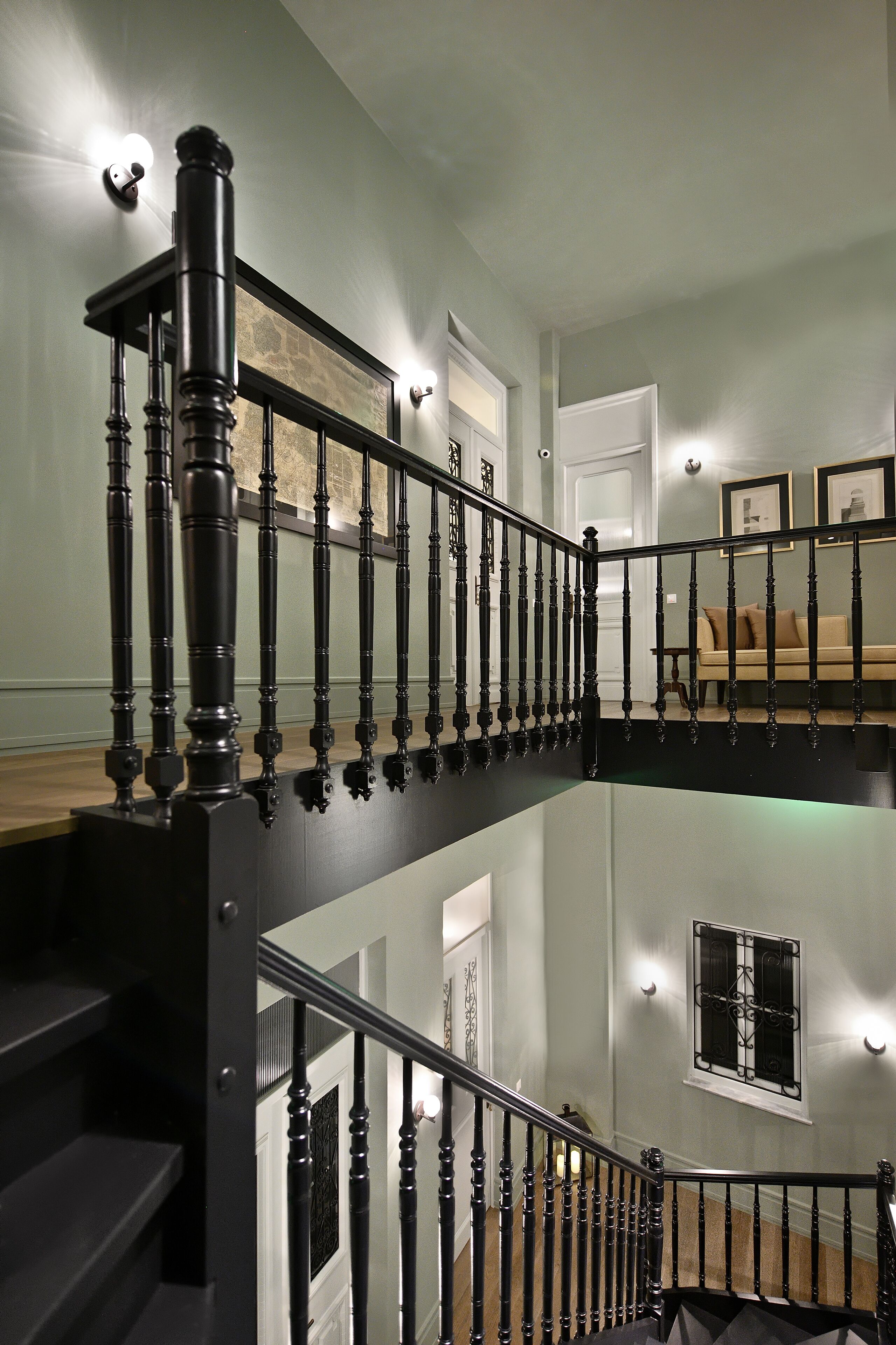 A multi-level staircase with black railings and a wooden handrail.