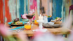 Een eettafel met eten, glazen en een kaars.