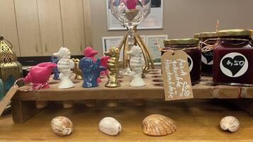 A wooden display with various decorative items including seashells, ceramic figurines, and a glass vase with a price tag.