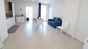 A modern apartment with a kitchen, dining area, and living room.