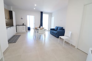 A modern apartment with a kitchen, dining area, and living room.