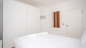 Une chambre à coucher avec un lit, une armoire et un miroir au mur.
