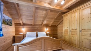 A wooden bedroom with a bed, bedside tables, and a wardrobe. - Apartment "Ferienhaus Pichlerhof" with Mountain View, Shared Garden & Wi-Fi (Fundres)