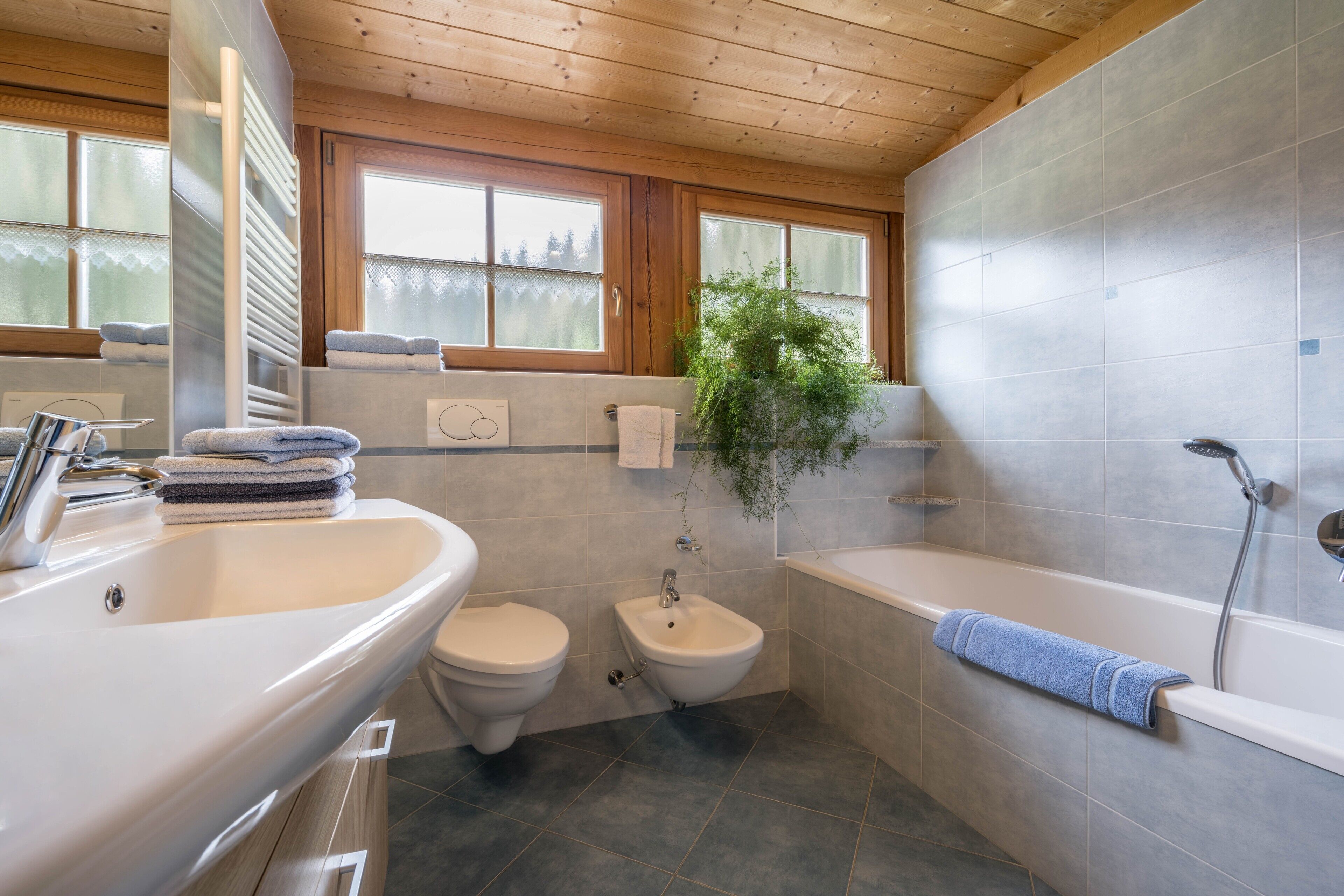 Een badkamer met een wastafel, toilet, bidet en bad.