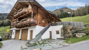 A wooden chalet with a balcony, stone steps, and a stone wall. - Apartment "Ferienhaus Pichlerhof" with Mountain View, Shared Garden & Wi-Fi (Fundres)