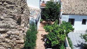 Un cortile con piscina, pareti in pietra e tetti tradizionali in tegole.
