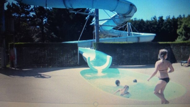 Un parc aquatique doté d’un grand toboggan et d’un espace piscine.
