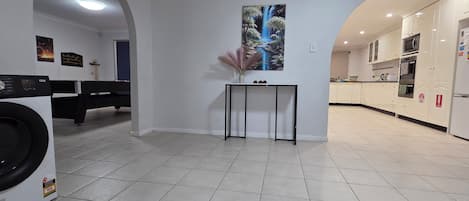 Una cocina moderna con armarios blancos, horno empotrado y refrigerador.