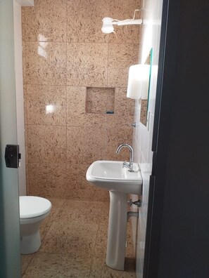 A bathroom with a toilet, sink, and shower area. - Hostel Goiânia.. (Goiania)