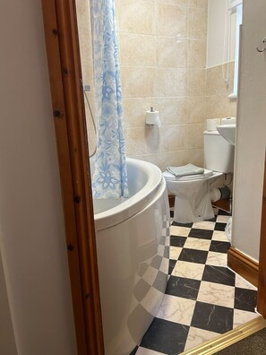 Ein Badezimmer mit Toilette, einer Duschvorhang und einem Schachbrettboden.