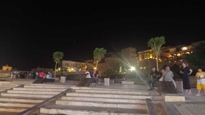 A nighttime outdoor area with steps leading up to a building, surrounded by trees and illuminated by streetlights. - mardin konağı (Mardin)