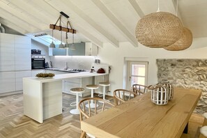 Eine moderne Küche mit Kochinsel, Barhocker und Pendelleuchten.