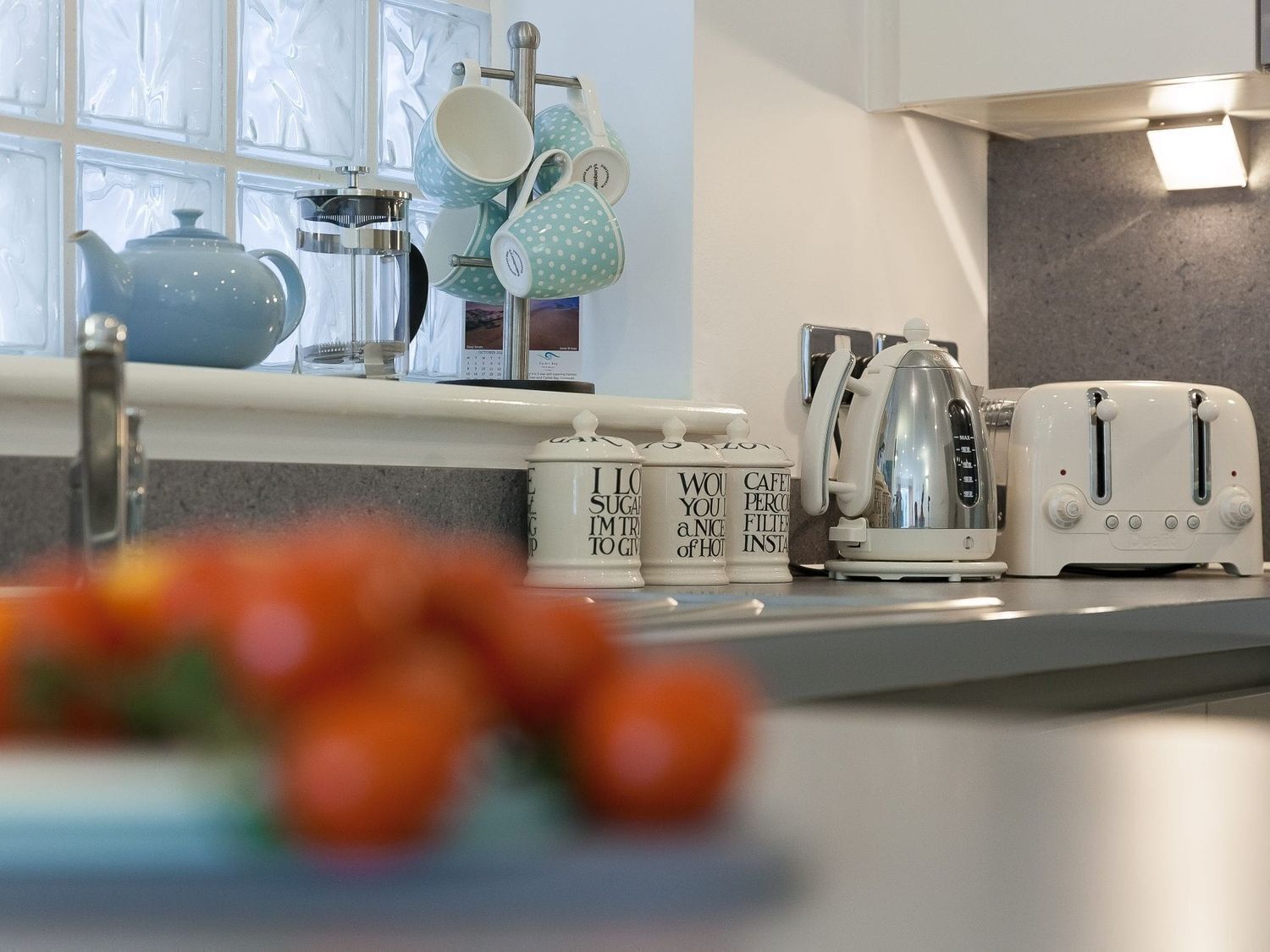 A kitchen with a coffee maker, toaster, and a window with a view.