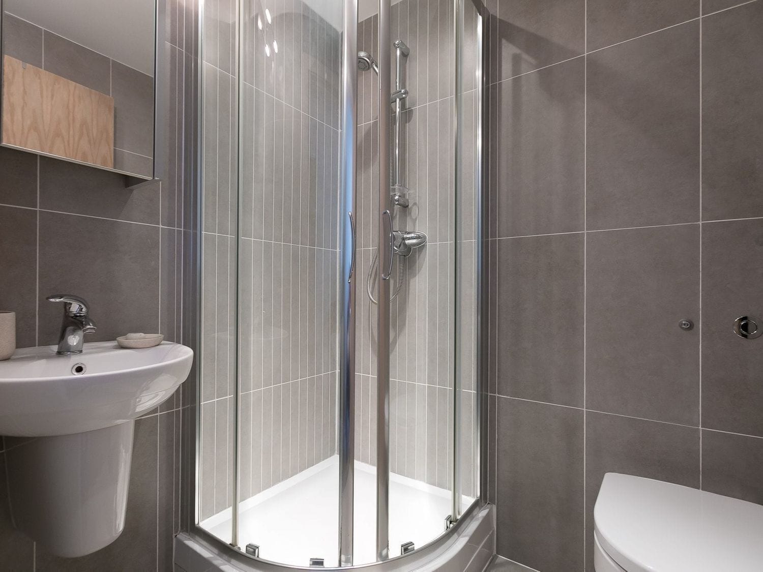 Une salle de bain moderne avec une douche à parois de verre, un lavabo et des toilettes.