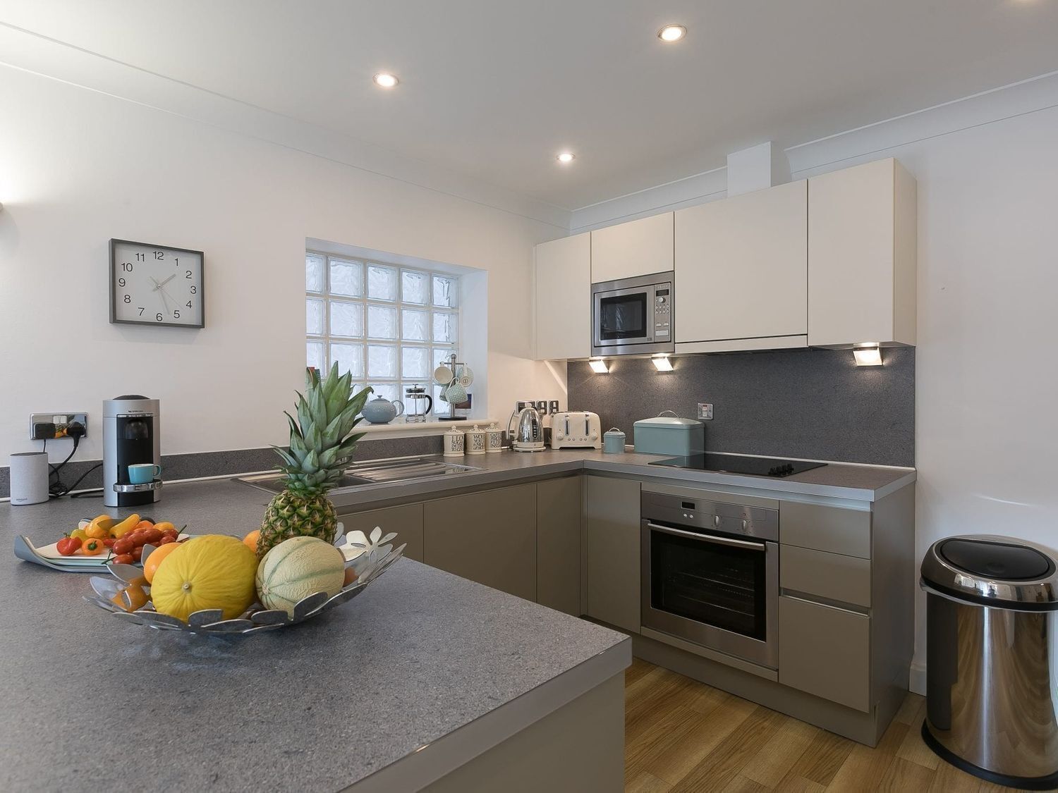 A modern kitchen with a central island, stainless steel appliances, and a window providing natural light.
